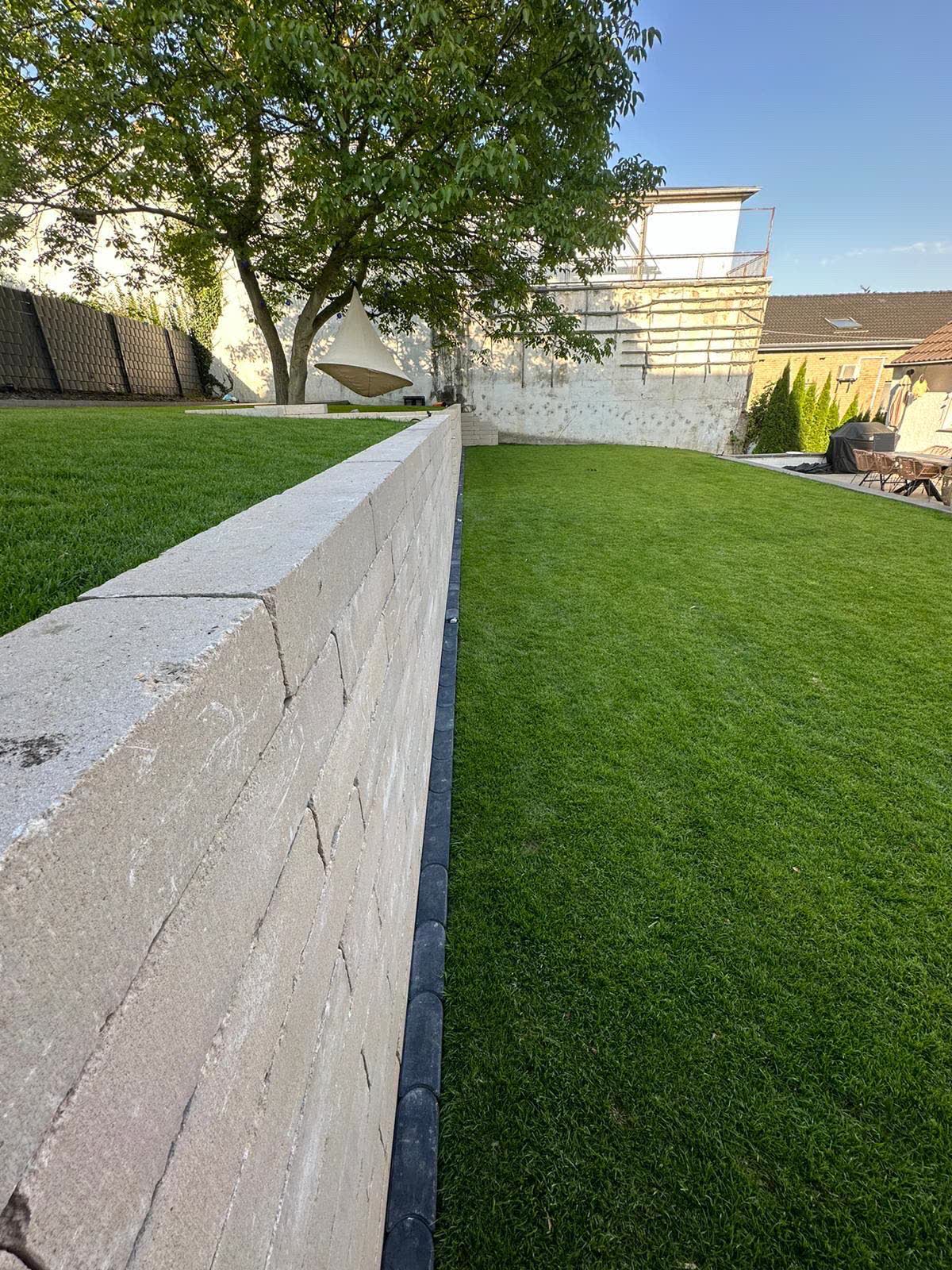 Stuetzmauer mit Rollrasen und sauber eingefasster Gartenflaeche in Bonn